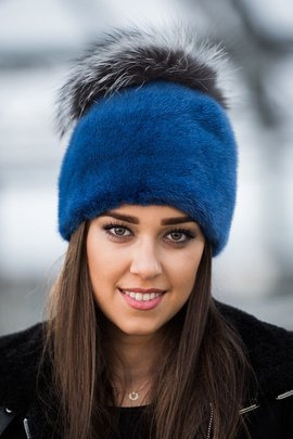 Czapka z naturalnego futra norek barwiona na kolor niebieski z pomponem w rozmiarze XXL z naturalnego  futra lisa srebrnego.