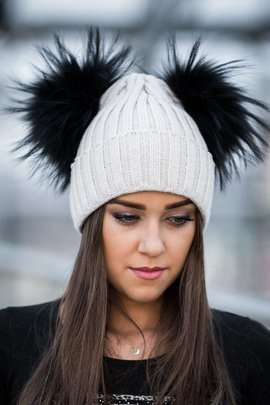 Czapka wełniana z mankietem w kolorze ecru z dwoma pomponami w rozmiarze XXL  z naturalnego  futra jenota barwionego na kolor czarny.
