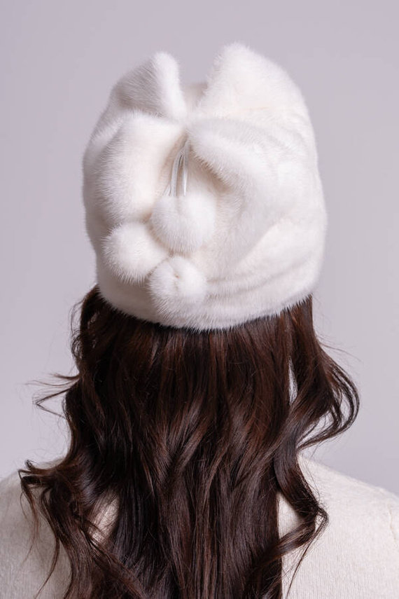 Biała czapka z norek z ozdobnymi pomponikami 